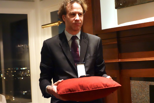 Gilles Delcourt (Deputy Cultural Attaché) holds the pillow with the medal.