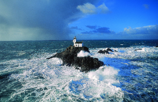 Waves crashing around a lighthouse in Brittany